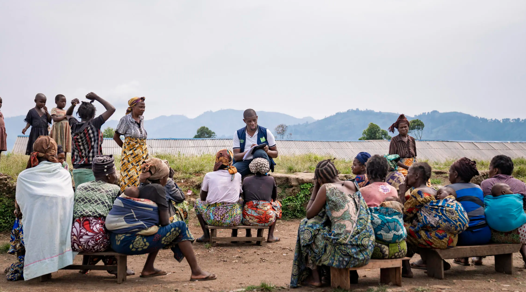 An aid worker speaks with displaced women in Masisi Territory, where families continue to seek safety after fleeing violence in surrounding areas. Photo: UNOCHA/Francis Mweze